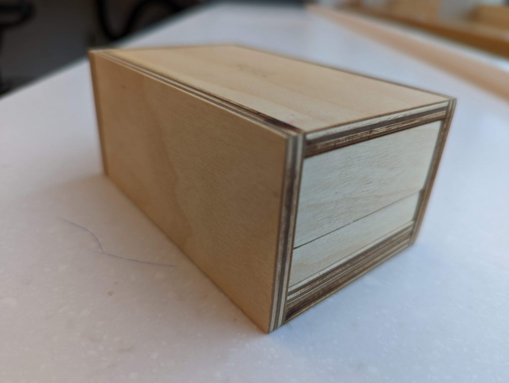 Assembled and nested apple boxes on white surface.